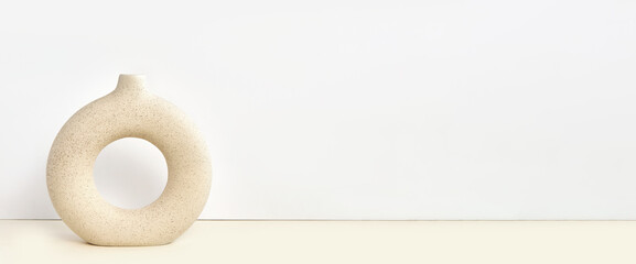 Stylish Circle Round Ceramic Vase on a Table. Detail of Contemporary Cozy Interior. Blank Space for Text on the Wall. Nordic Beige Background. Minimalistic Scandinavian Style. Empty Mockup