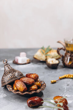 Ramadan table, dates on the background of traditional dishes with dried fruits, fresh garnet, tea.