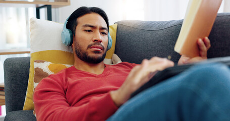 Man entrepreneur thinking, inspiration and writing notes in a book with headphones on the sofa in the living room. Student, journalist and creative author with idea, planning and strategy in notebook