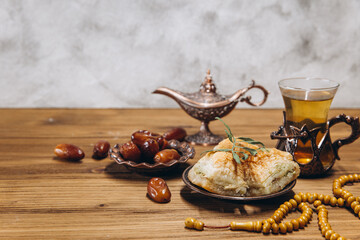 Ramadan concept, cup of tea, plate of sweet dates and baklava, copy space