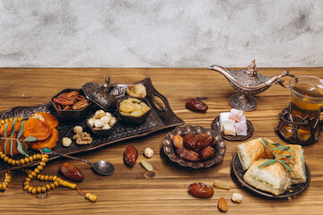 Dried dates and tea on a wooden table. Arabic traditional dishes, pots and dates fruits. Ramadan Kareem, Eid mubarak concept. Copy space