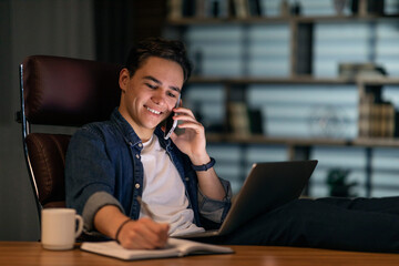 Young guy freelancer working from home office at night