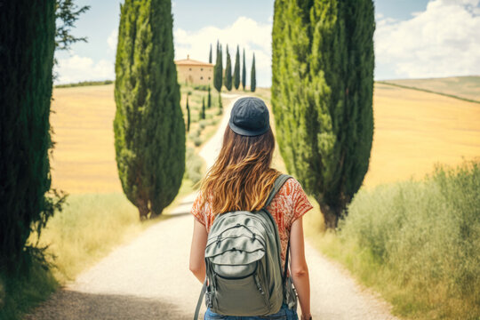 Tourist girl with backpack walking in cypress alley in Tuscany, Italy. AI generative