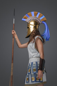 Shot of isolated on grey background greek soldier woman holding spear.