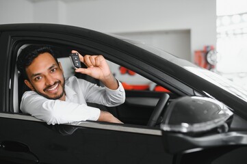Happy indian man showing the key of his new car