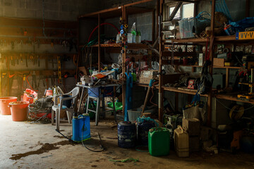 Fototapeta na wymiar farm impliments cluttered inside a barn