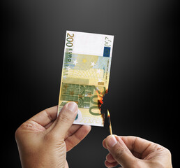 Burning money. Male hand setting a 200 euro bill on fire.  Europe euro. 3d rendering.