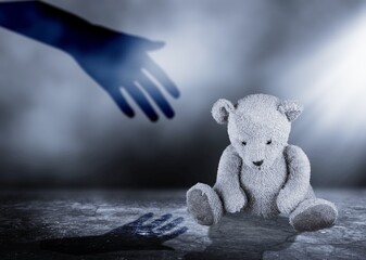 Toy bear and hand shadow, child abuse concept