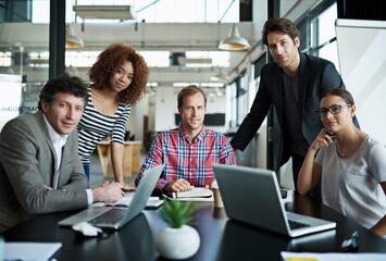Great designing minds. Portrait of a group of smiling office workers sitting around a table.