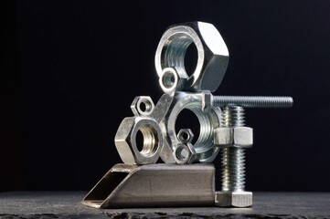 composition of nuts bolts and scraps of metal laid out on a dark background.