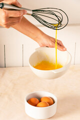 Woman beating eggs in ceramic bowl to prepare breakfast; movement