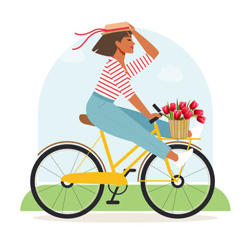 A happy woman in a panama hat with tulips in a basket rides a bicycle and rejoices at the beginning of spring. A cute girl is enjoying summer while improving her physical and mental health. 