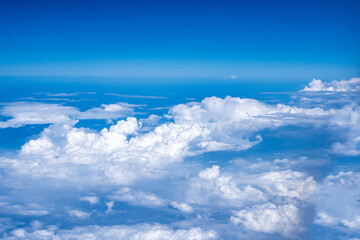 Clear blue sky with white clouds view from a plane window. Airplane creative shot.