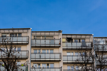 Facade with balconies in an apartment block. Multi-family housing, the object against the blue sky.