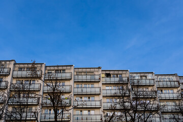 Facade with balconies in an apartment block. Multi-family housing, the object against the blue sky.