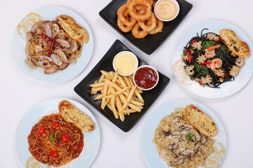 set of various plates of food, pasta dishes, onion ring, french fried, isolated on white background, top view.