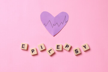 National Epilepsy or Alzheimer disease Day Concept. Purple heart shape with epilepsy lettering on pink background.  