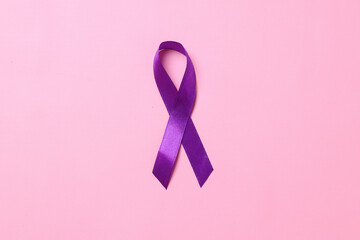 World cancer day, hands holding purple ribbon on pink background. Healthcare and medical concept....