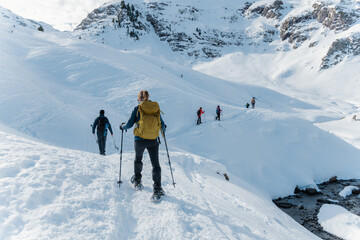 Fototapeta na wymiar group of mountaineers doing a route with snowshoes in winter on a sunny day in the pyrenees