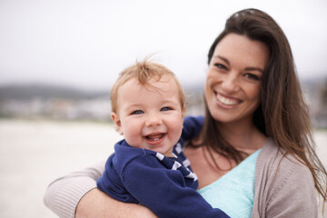 Mommy and me time at the beach. Portrait of a an attractive young woman holding her baby boy at the...
