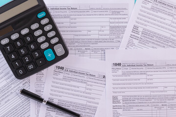 Tax fill concept, pen and calculator  with 1040 U.S. form backgound