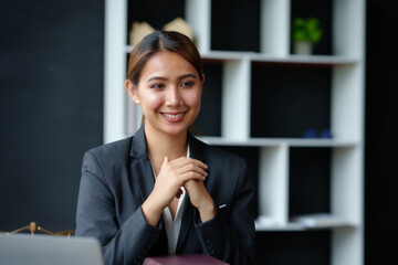 Attractive asian businesswoman sitting working on laptop thinking new idea at office.