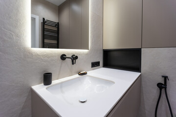 Modern black fittings in the bathroom. black faucets framed in mirror and decorative elements.