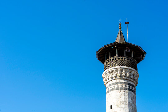 Minaret of historical Habibi Neccar Mosque in Antakya (Hatay) Turkey, on the background of blue sky before the earthquake of 2023. Copy space for text.