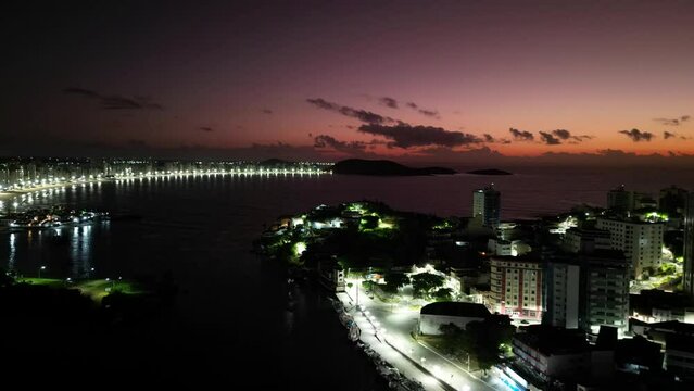 Imagem aérea noturna da cidade de Guarapari no Espírito Santo. Praia do Morro e Centro de Guarapari com luzes noturnas.