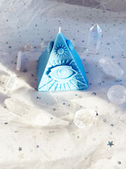 Esoteric candle clairvoyant pyramid surrounded by crystals. Background Healing minerals, stones, crystals. the practice of magic spells and cleansing. Crystal Ritual, Witchcraft..