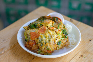 Rice with Minced pork mixed vegetables omelet  White Plate wood table focus view 