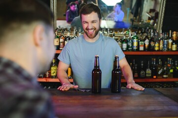 Handsome bar tender standing behind his counter in a pub