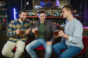 Friends resting in the pub with beer in hands. Having conversation.