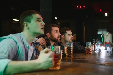 Group of excited friends in beer pub watching sports match