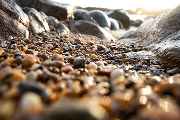 Low view of foreground gravel and rocks in the cold sunset light in winter at Porto beach - Portugal