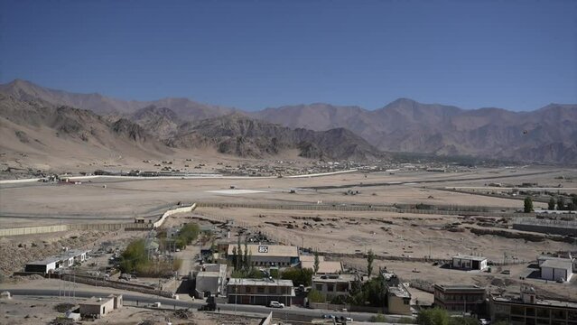 Leh airport with its runway and buildings with mountain range and blue clear sky