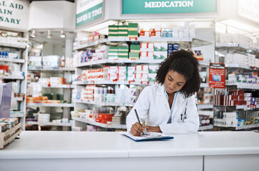 Ill leave you some instructions. Cropped shot of an attractive young female pharmacist working in a...