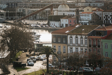 Fototapeta na wymiar Pier and boats seen from above, buildings by the river Ave in the late afternoon in Vila do Conde, Portugal