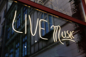 Neon sign saying "Live Music" in the bar window - Powered by Adobe