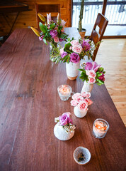 white vases with roses in a wooden cabin - spring decoration