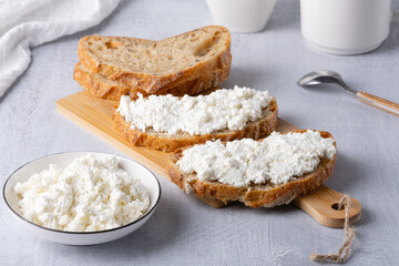 Bread with curd cheese on wooden board