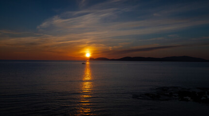 super sunset at the ramparts of alghero city with human silhouette
