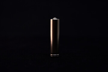 A shiny electric battery on a black background. The battery is a close-up.