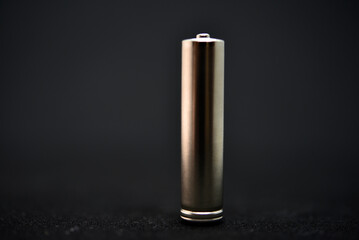 A shiny electric battery on a black background. The battery is a close-up.