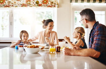 Sharing stories at the breakfast table. Cropped shot of a family enjoying breakfast together.