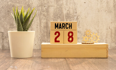 March 28 calendar date text on wooden blocks with blurred park background. Copy space and calendar...