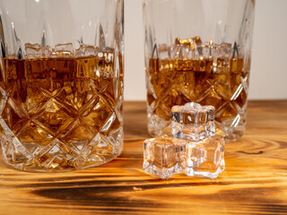 A glass of cognac with ice cubes. A glass of whiskey or bourbon with ice. Close-up.