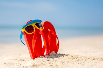 Women yellow sunglasses and red flip-flops on sandy. Travel by sea. Beach vacation.tropical sandy...