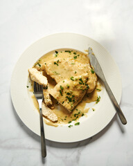 Chicken breasts in mustard sauce on white plate