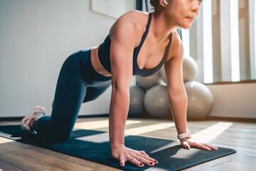 Fototapeta na wymiar Asian woman doing plank and stretch legs and arms on yoga mat at Gym in the morning.Exercise, Workout and fitness lifestyle concepts.
